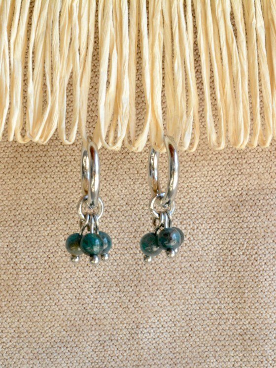 Aretes Belai Apatita Trio, argollas de acero con racimo de tres cuentas redondas de apatita azul, apoyados sobre fibra de rafia y lino